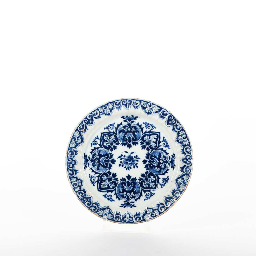 Null 德尔福

陶器餐盘，有棱角的边缘，用蓝色单色的卡图和花朵装饰。

标记APK。

18世纪。

直径：22厘米

(筹码)