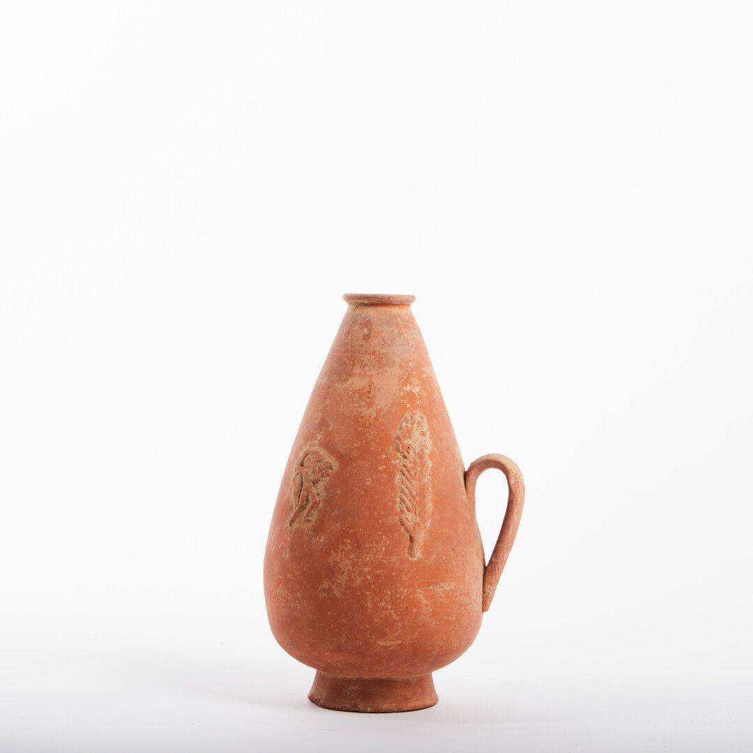 Null 红色赤土花瓶

1个手柄，装饰有棕榈树、动物、字符

优秀的保存状态

罗马，3/5世纪

高度：19厘米