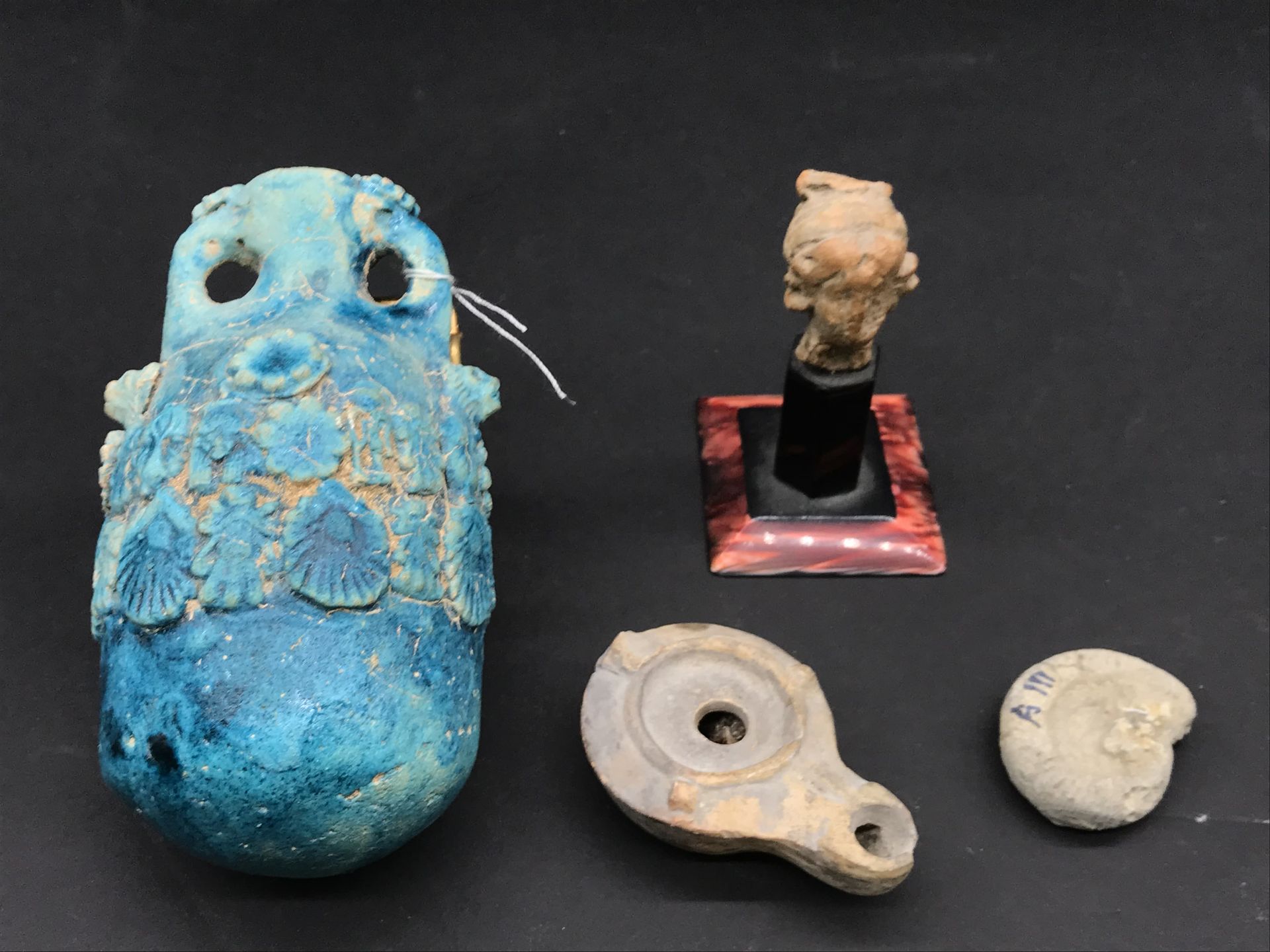 Null 一套四件挖土机，包括 :

- 陶俑头像（高4厘米，已修复）。

- 一盏油灯（长6.5厘米，碎片）。

- 氨石化石（长3.8厘米

- 蓝釉油瓶（&hellip;