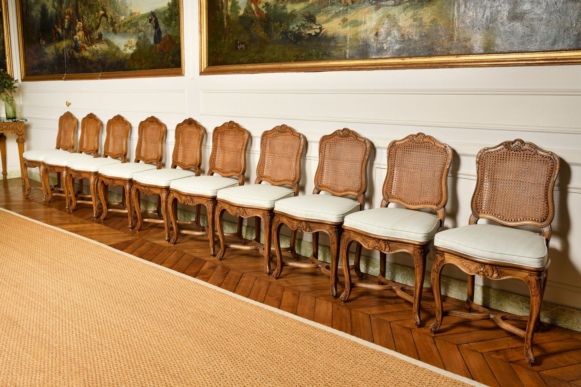 Null A SET OF TEN MOVED BACK CHAIRS, in natural wood moulded and carved with flo&hellip;