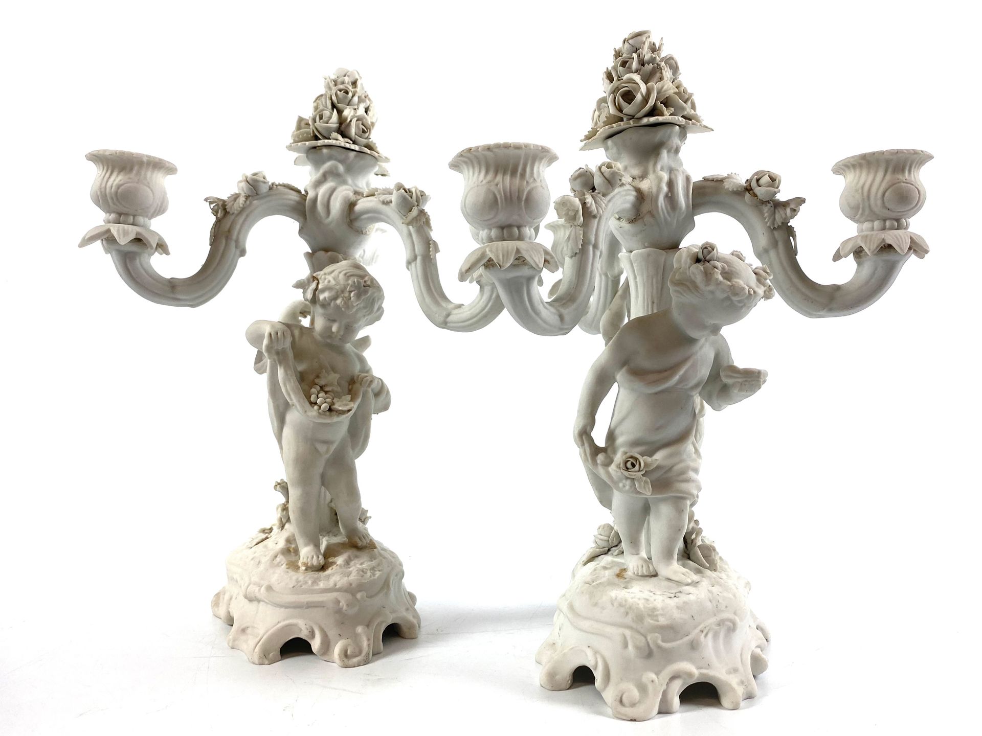 Null 一对饼干烛台，有三个活动的灯臂，装饰有小天使在一个自然的露台上，19世纪 高：28厘米（有缺口和丢失的部分