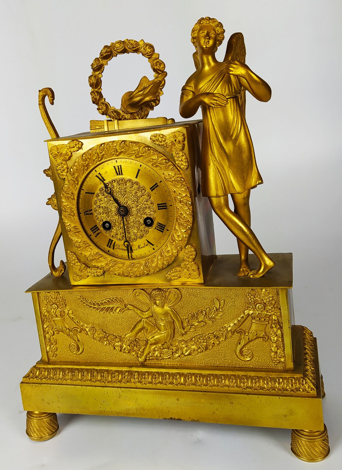 Null 一个装饰有丘比特和他的属性的木制和带凹槽的青铜钟。 鎏金表盘上有Moulins的DURAND签名。修复期 29 x 22 x 9 厘米（缺失和磨损）。
