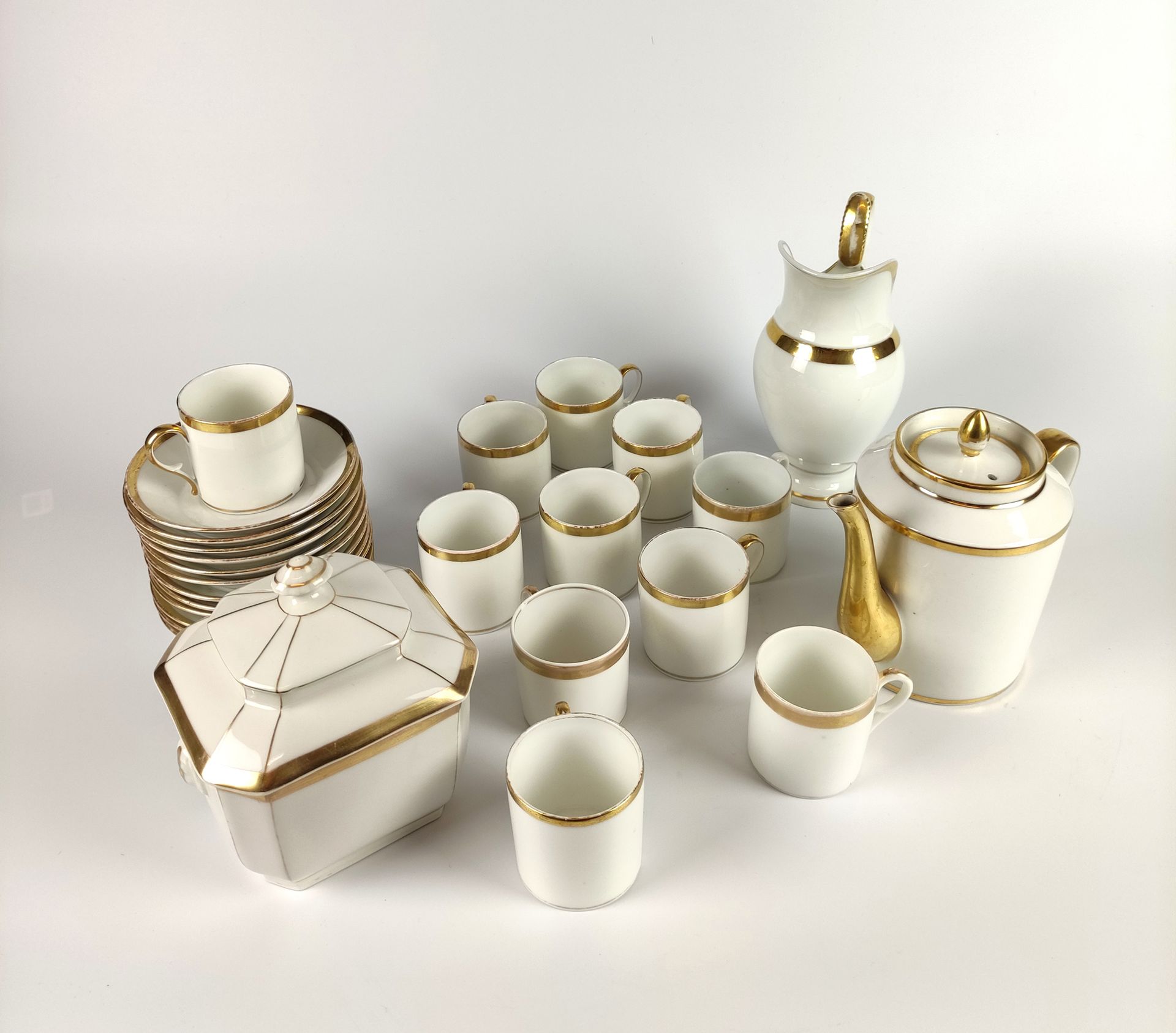 Null 巴黎茶具，白色和金色的瓷器，包括。- 一个茶壶 - 一个糖碗 - 一个牛奶壶 - 11个杯子 - 12个碟子 19世纪（有缺口和划痕