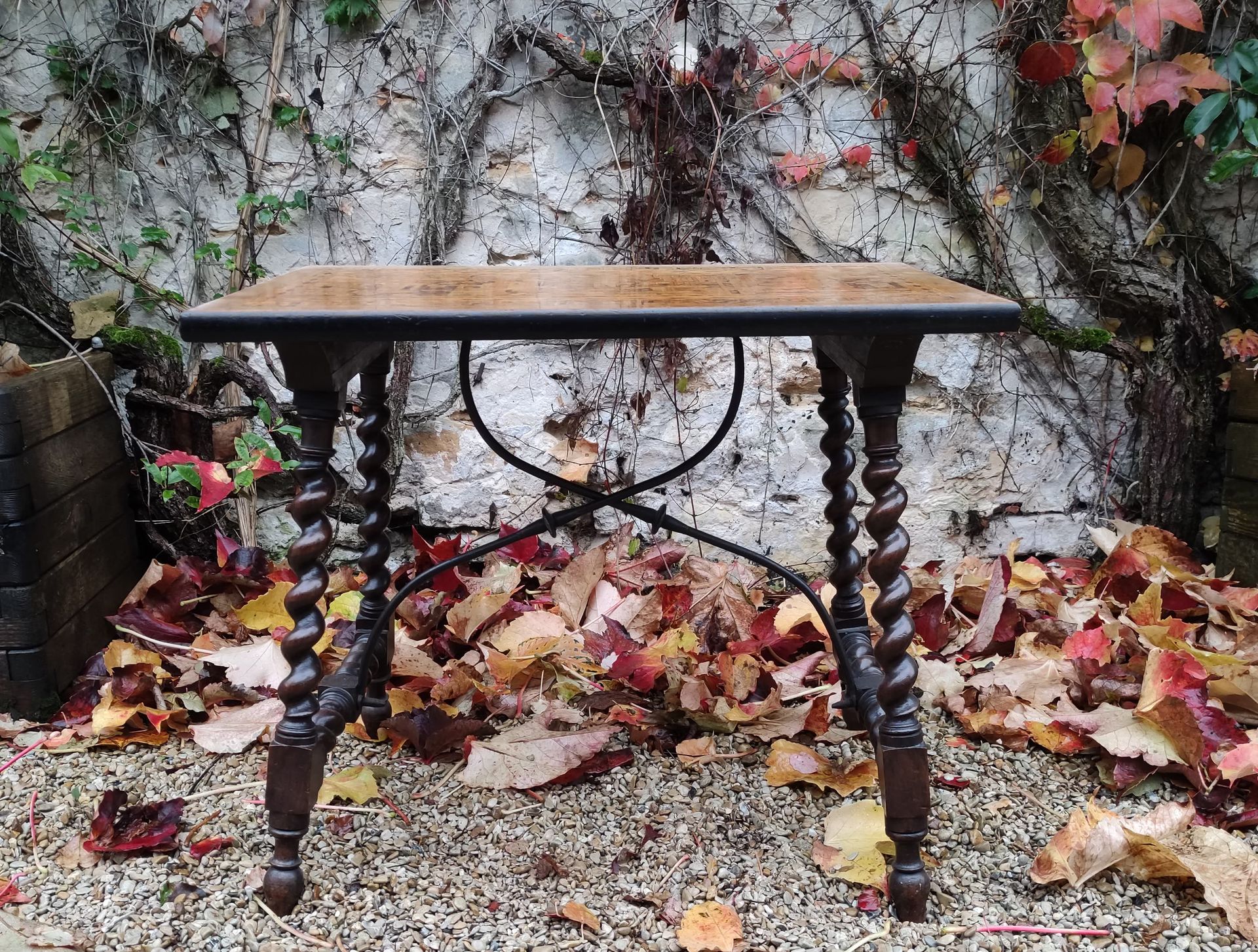 Null 一张着色的木质写字桌，四条扭曲的腿由一个双锻铁杆连接，长方形的桌面上镶嵌着古代遗迹的装饰。部分是17世纪。(日照的痕迹，修改）。)