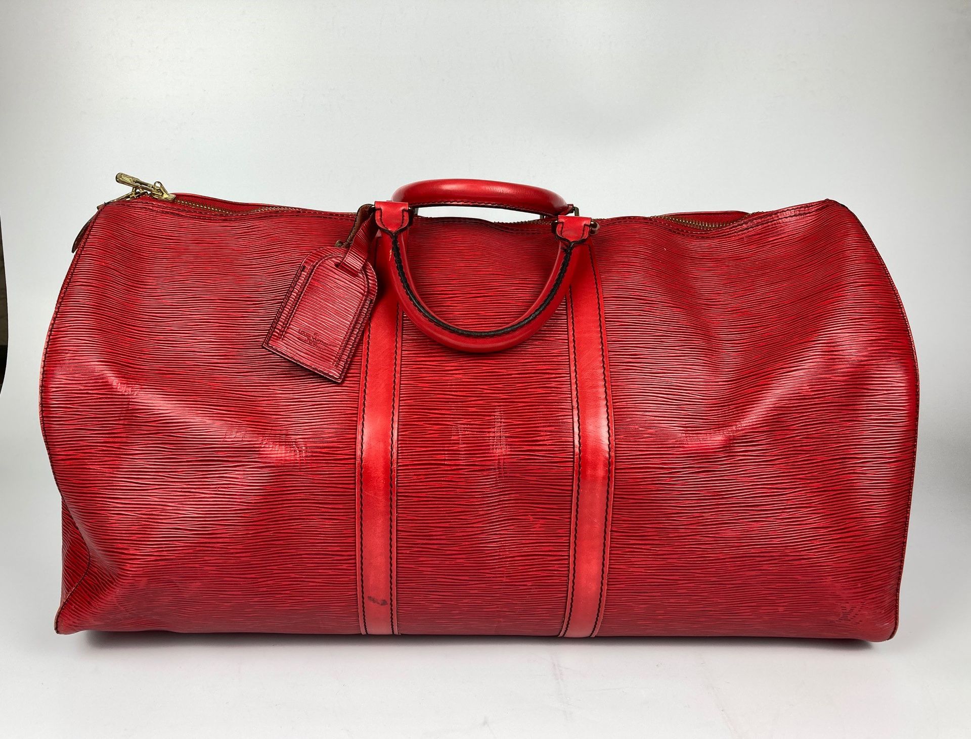 Null 路易威登旅行包，"Keepall" 55型号。红色Epi皮革，镀金金属装饰，顶部有拉链，一个小侧袋，两个手提把手，有地址夹。(边角磨损，缺失，摩擦和污&hellip;