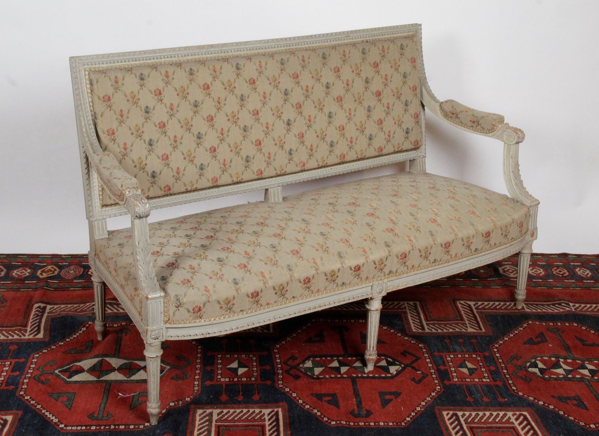 Null 一张直背沙发，用模制的木头，雕刻和灰色的漆，装饰着扭曲的丝带，水叶，滚动的刺桐叶和玫瑰花。它站在五个锥形和凹槽的腿上。 年代：路易十六风格，19世纪末&hellip;