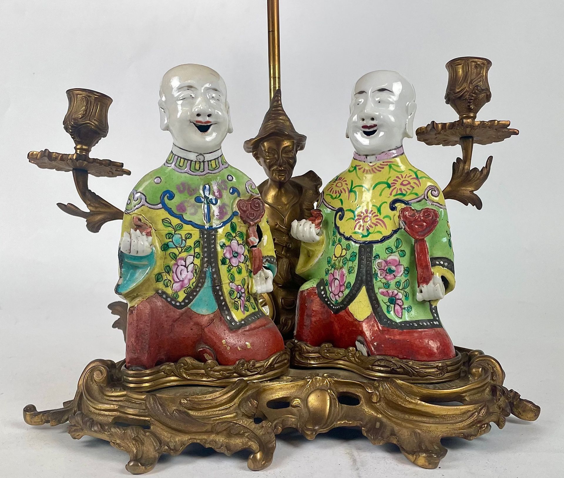 Null 一件中国鎏金青铜及镂空叶子的烛台，有两个移动的灯臂，卷轴式的底座有罗盖尔的装饰，上面有两个多色的中国瓷器霍布（事故）。 19世纪。 高：21厘米（不含&hellip;