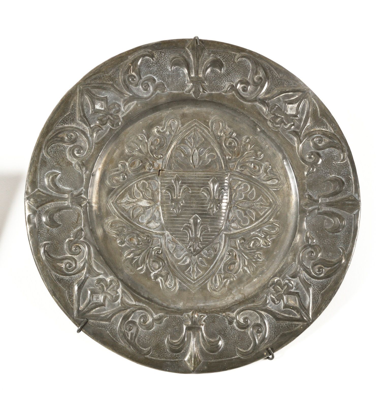 Null 带有法国国徽的圆形挂盘，边缘饰有百合花和叶子。 烫金的锡器，底部有双层。直径：35厘米。19世纪下半叶的作品。