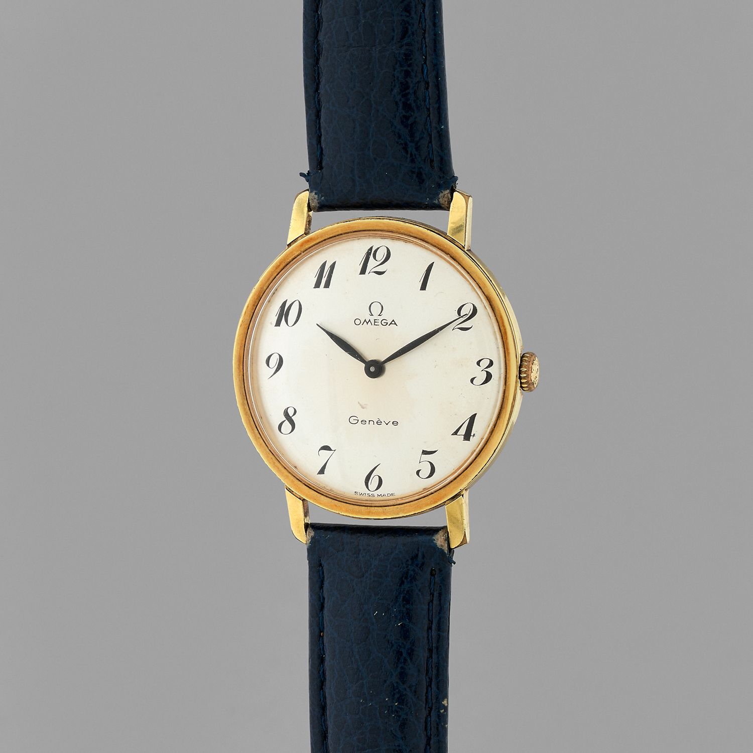 Null 欧米茄
瑞士，日内瓦。
约：1960年。
镀金的腕表。圆形表壳，金色表盘上有阿拉伯数字。黑色的手。机械机芯，手动上链。蓝色皮表带和针扣。

直径：34&hellip;