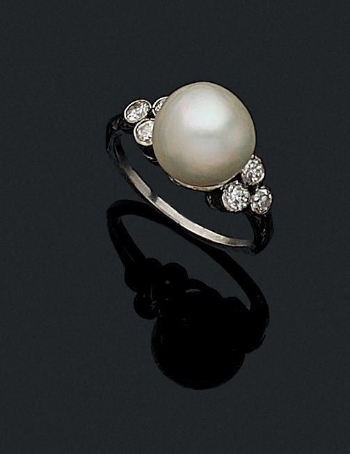 Null BAGUE 

retenant une perle blanche de culture épaulée de 6 diamants taille &hellip;
