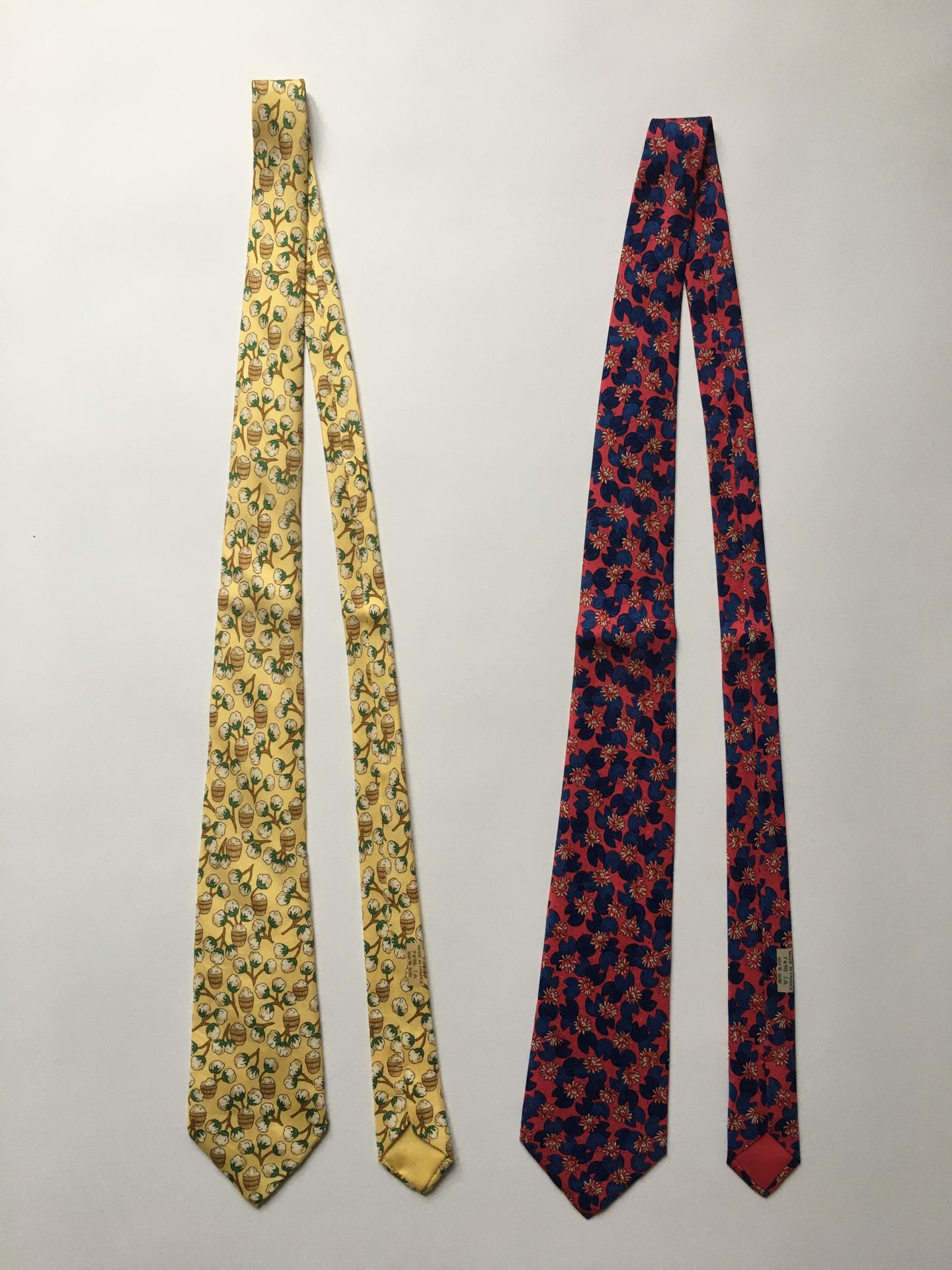 Null HERMES 
Due cravatte in seta stampata con fiori su sfondo giallo e lampone &hellip;