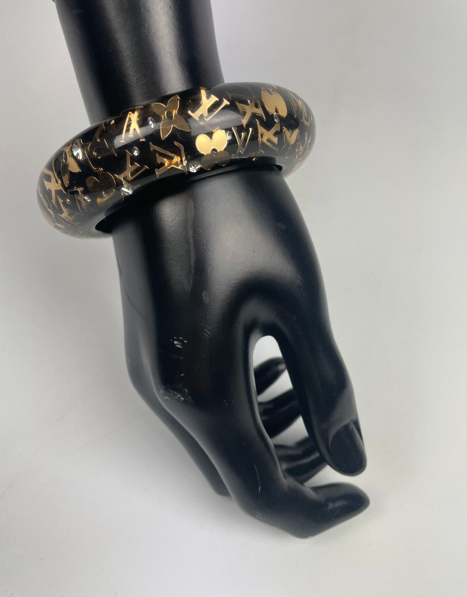 Null 路易-威登（LOUIS VUITTON
黑色包容手链，带有金色的字母和流苏
直径：6.2厘米
(划痕)
