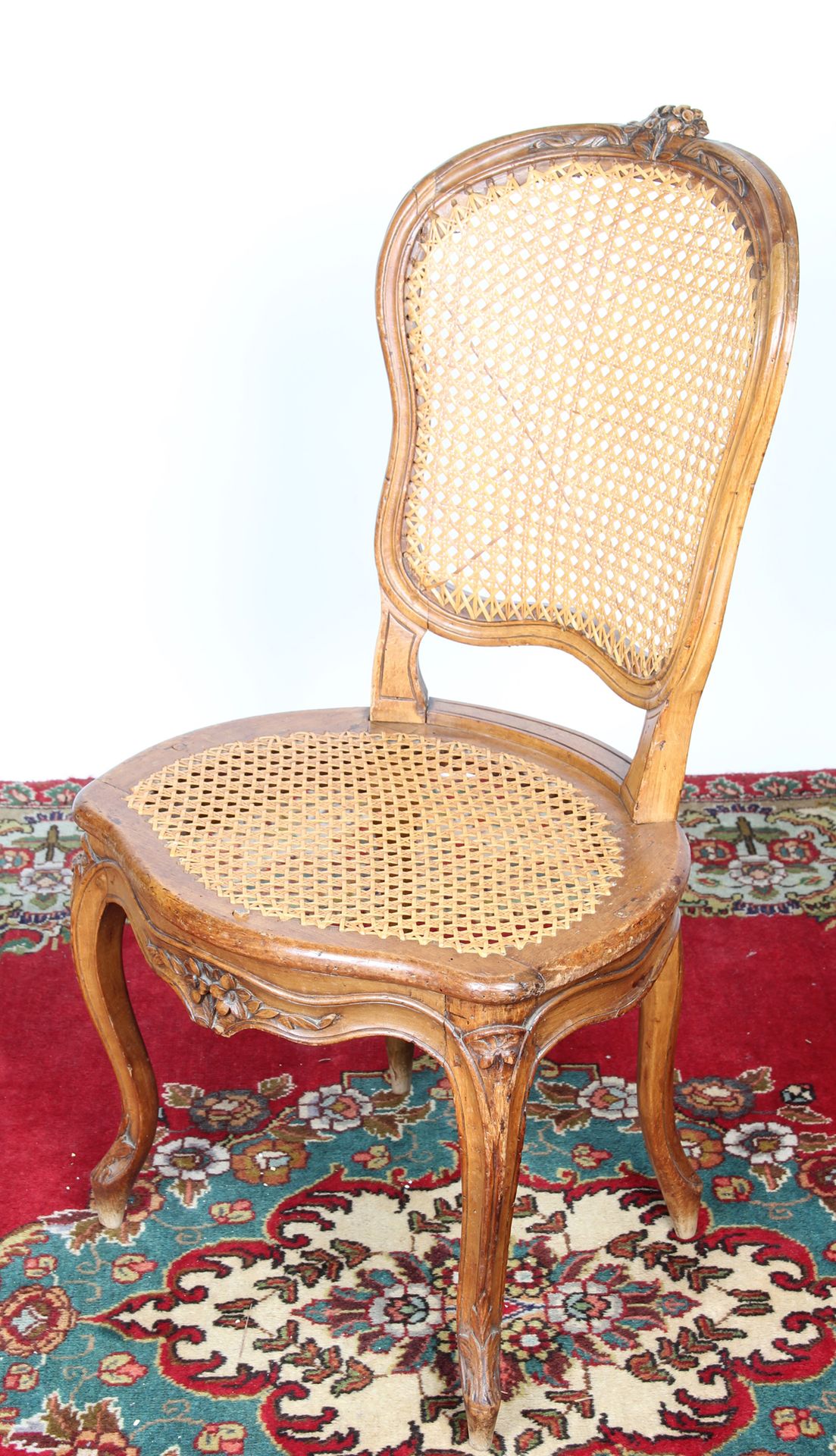 Null 模制和雕刻的木椅，椅背上有中提琴，花，叶子，刺桐叶和卷轴、 

它站在四个弯曲的腿上，有一个藤条的座位和背部。 

高：95.5 x 宽：51 x 深&hellip;