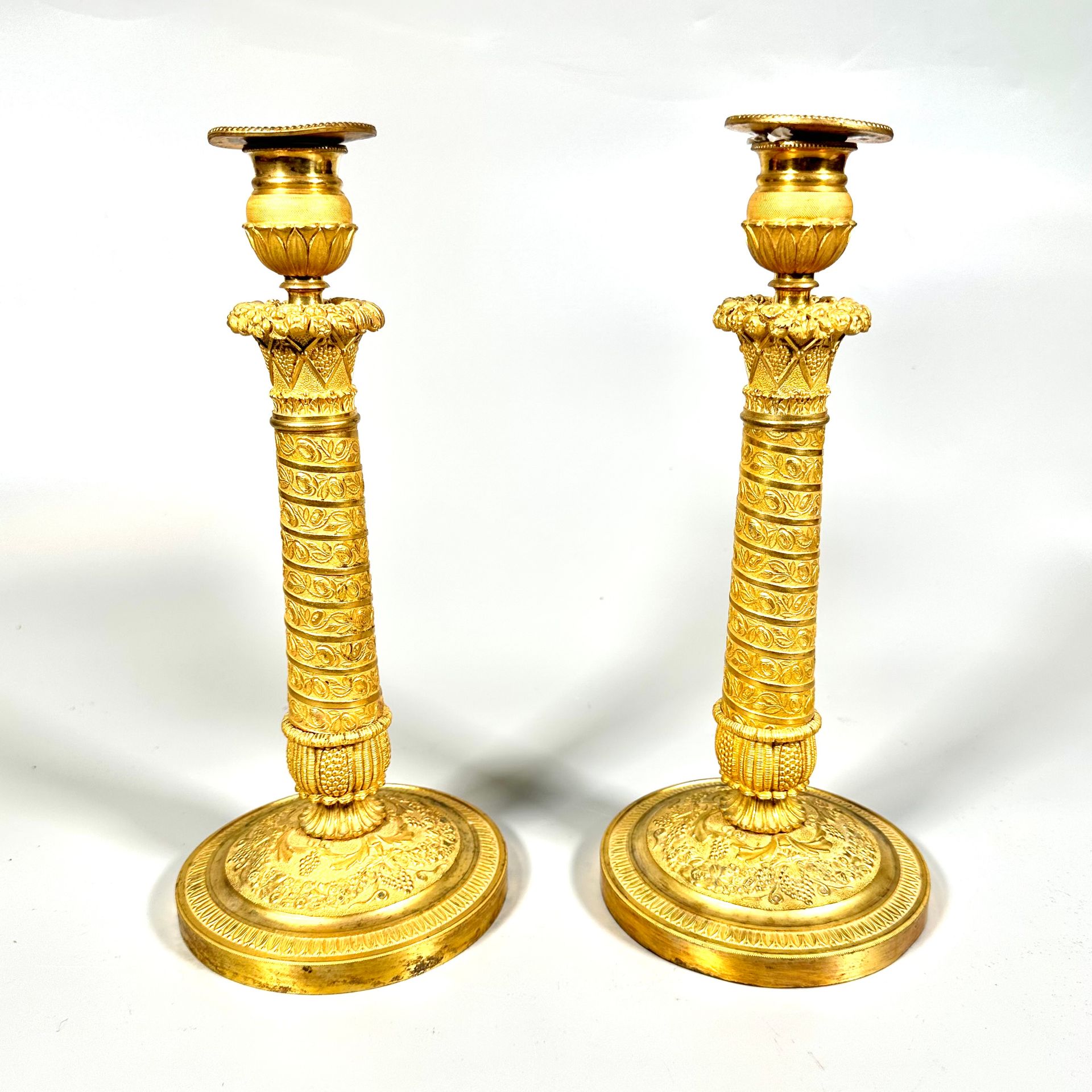 Null PAIRE DE FLAMBEAUX en bronze doré et ciselé à décor d’une colonne de guirla&hellip;