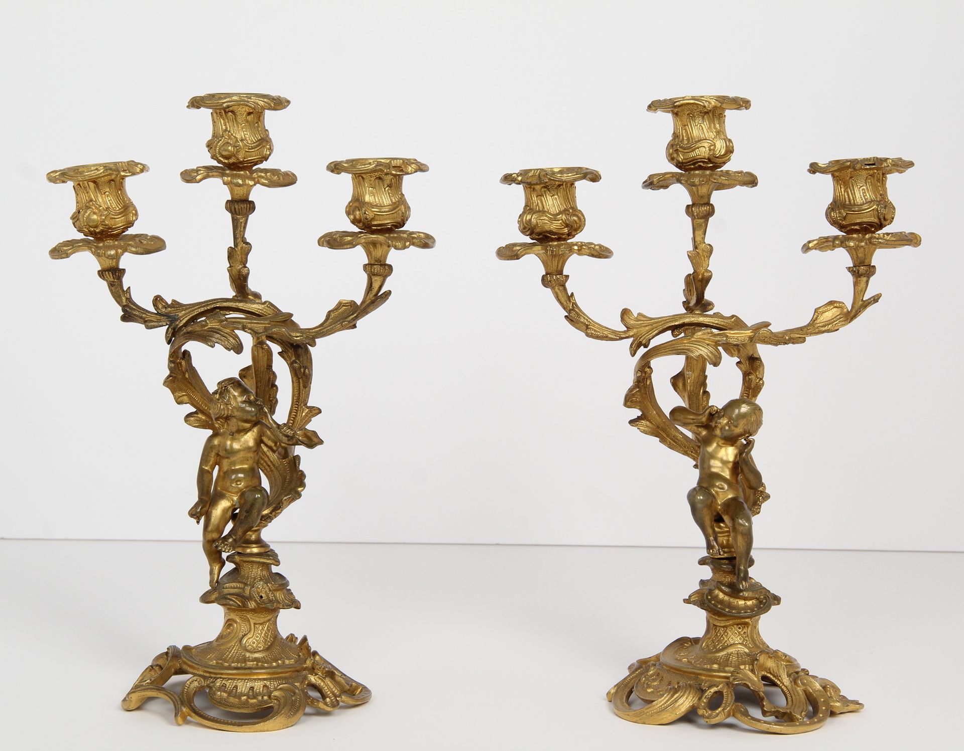 Null 烛台一对

镀金青铜三臂烛台，饰以卷轴式叶片，描绘了一个正在对着海螺壳吹气的孩子和另一个捂着耳朵的孩子。

路易十五风格。

时期：19 世纪。

H&hellip;