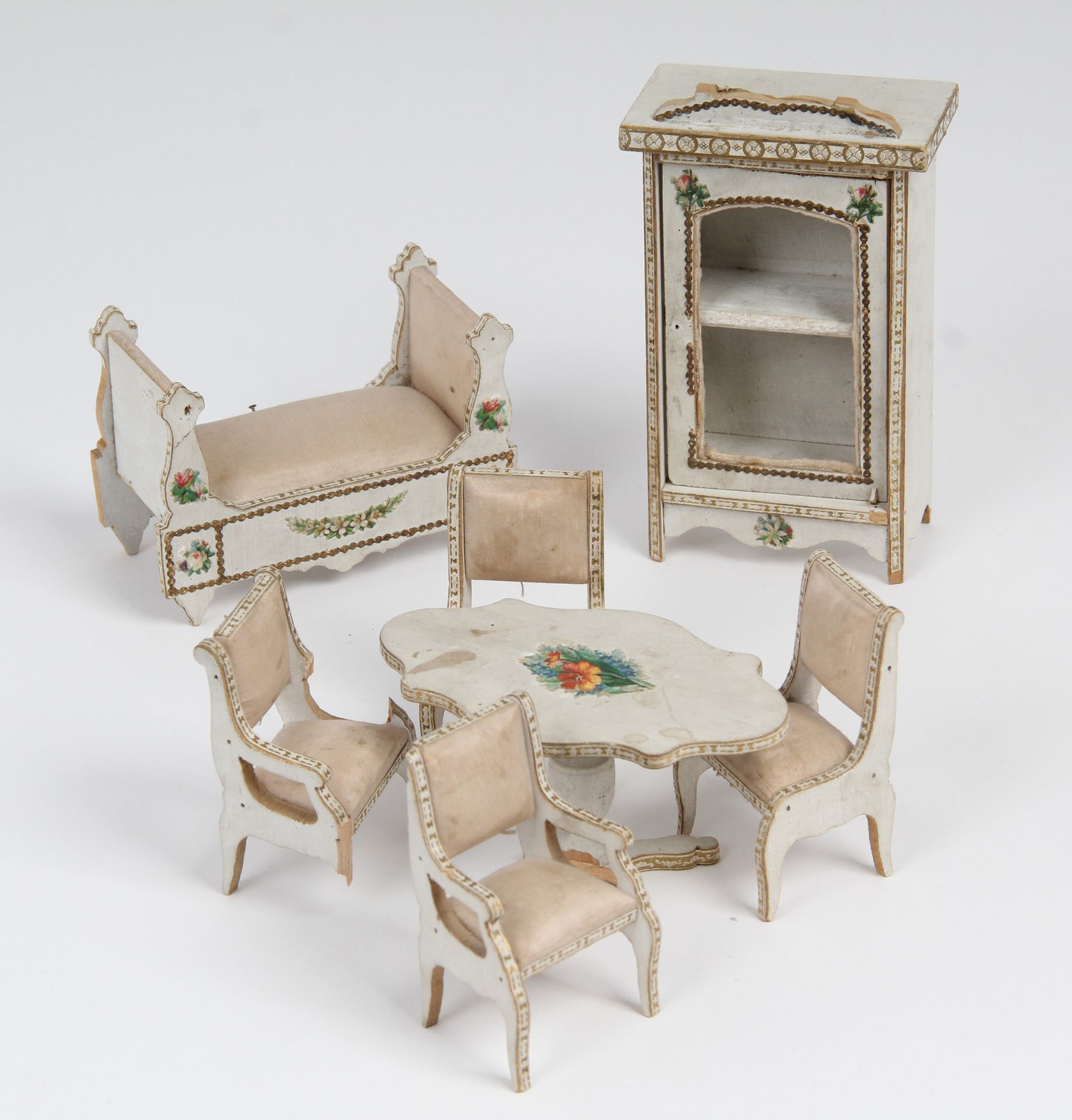 Null 玩偶家具

白色和镀金涂漆木质，带有彩绘图案。

它包括一个镜柜、两把椅子、两把扶手椅、一张座桌和一张日光浴床。

时期：19 世纪。

(损坏和缺件&hellip;