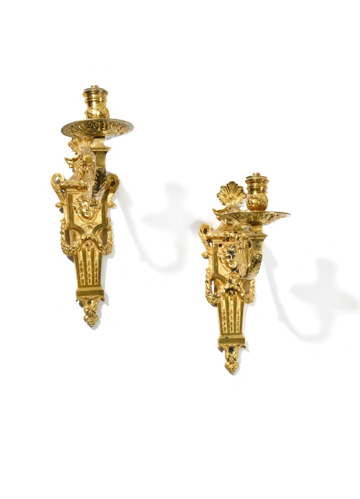 Null 一对单灯烛台 
鎏金青铜雕刻，饰有贝壳、马斯卡龙和叶子花环。
路易十四晚期至摄政时期。 
高度：26.5 厘米
(修复、铜锈磨损、电孔）