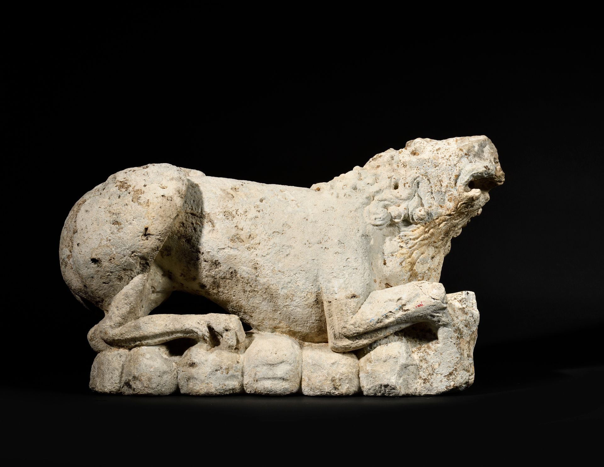 Null LION en pierre calcaire sculptée. 
Allongé, la tête légèrement relevée, il &hellip;