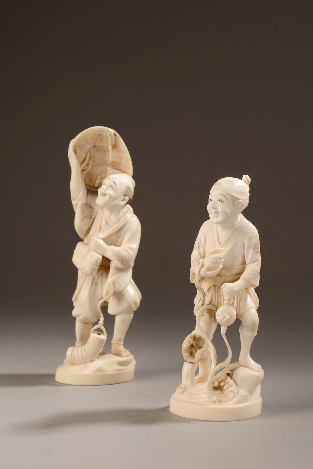 Null 日本 - 19世纪末，20世纪初。

两个象牙雕刻的okimonos（象科），代表一个渔夫和一个戴着帽子拿着灯笼的人（有小缺口和缺失）。

底座下的标&hellip;