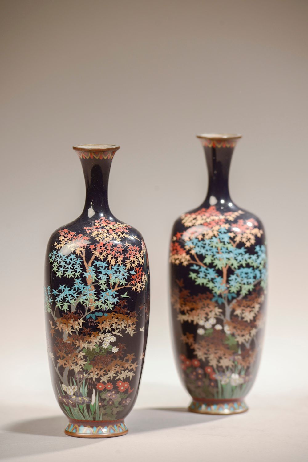 Null 日本 - 明治时期（1868 - 1912）。

一对铜制和掐丝珐琅的方形和阳台花瓶，在深蓝色的背景上装饰着枫树，鸢尾花和菊花。

高度。19 cm
&hellip;