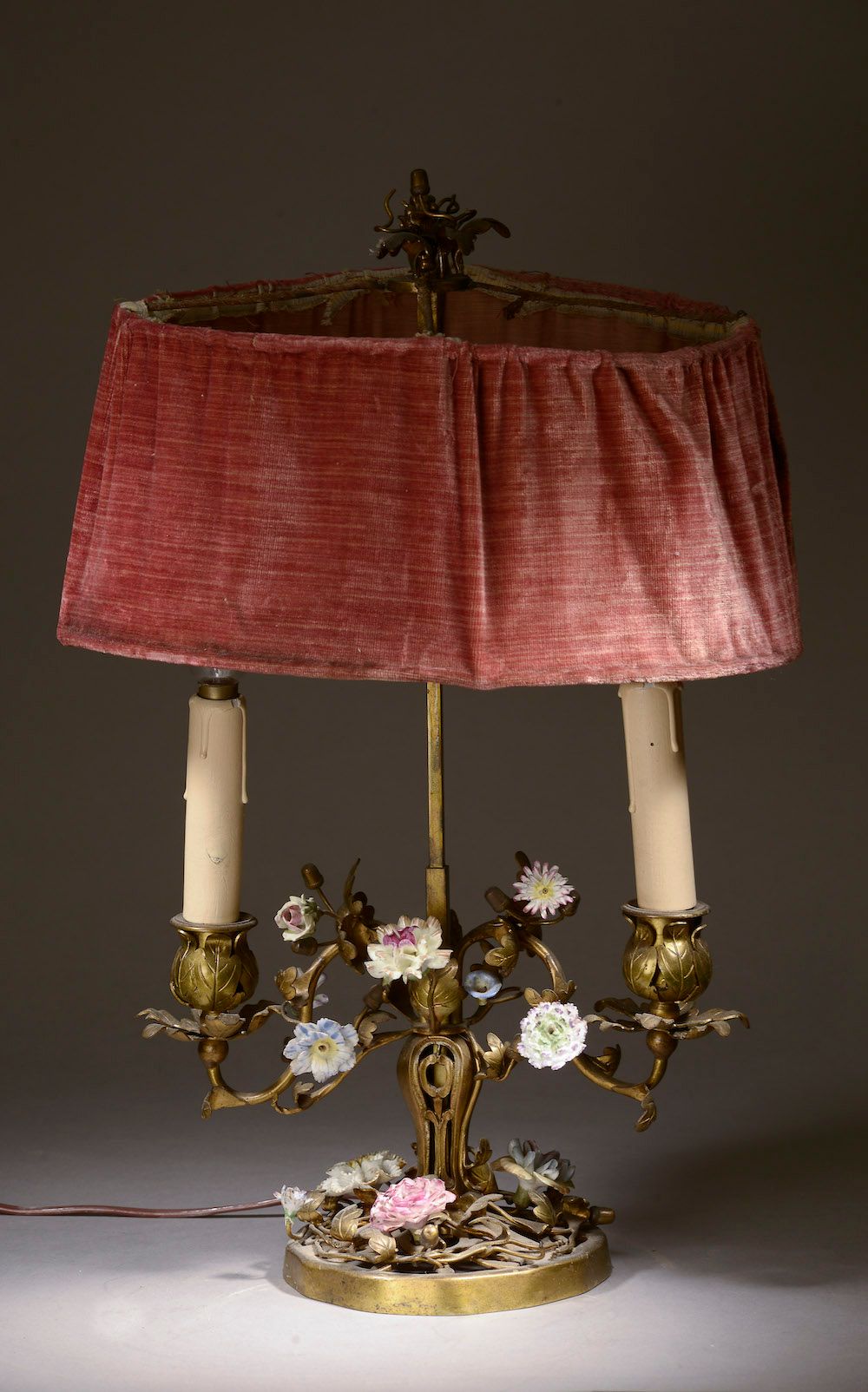 Null 镀金铜和金属板的双灯台灯，有瓷花。

路易十五风格，19世纪。

高度：49厘米-宽度：32厘米，可调节的天鹅绒灯罩，灯杆末端有一个爆裂的水果。49 &hellip;