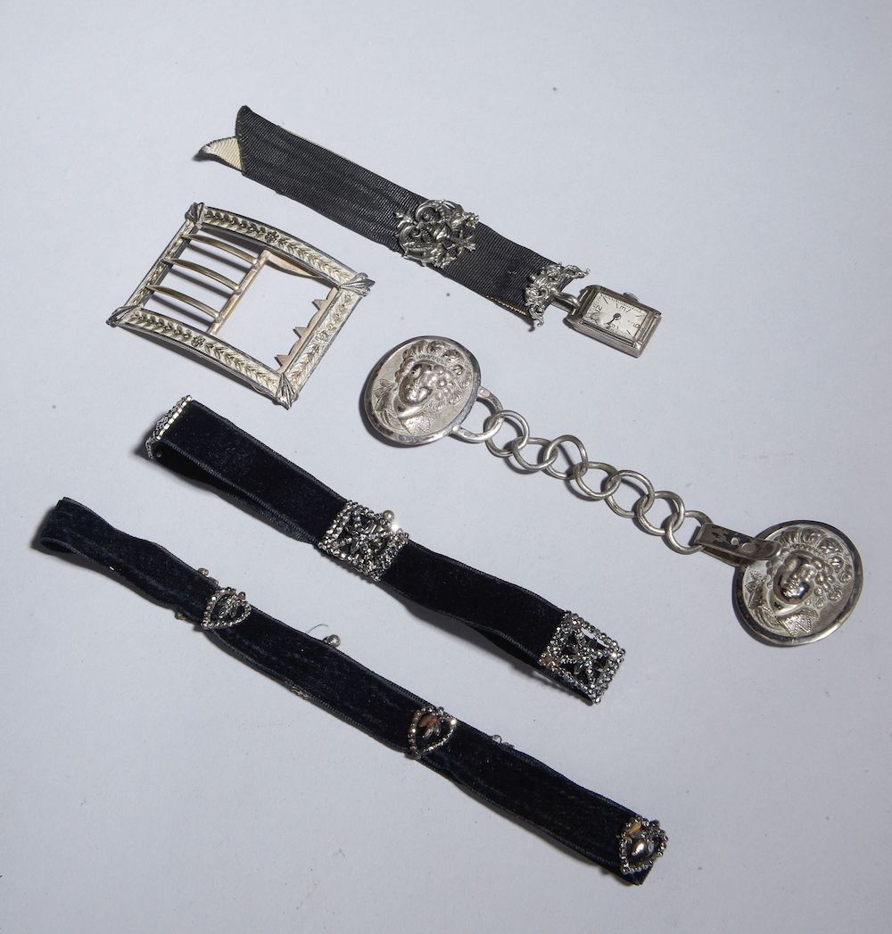 Null 一套19世纪的陈列柜包括：

- 两个黑色天鹅绒和切割钢制的吊饰。长度：38和30厘米

- 银质的披肩扣，上面有两个压印着人物半身像的勋章。重量：2&hellip;