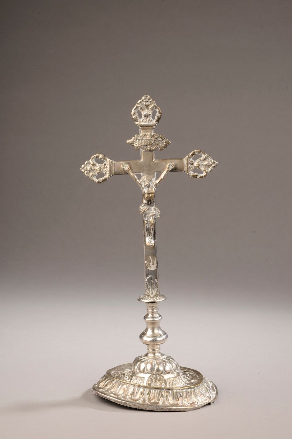 Null 
一个镀银的青铜祭坛十字架，头顶上有一个小山包，十字架的手臂末端是棕榈树。它放置在一个椭圆形的底座上，上面有叶子的装饰（底座变形，银饰磨损）。

19&hellip;