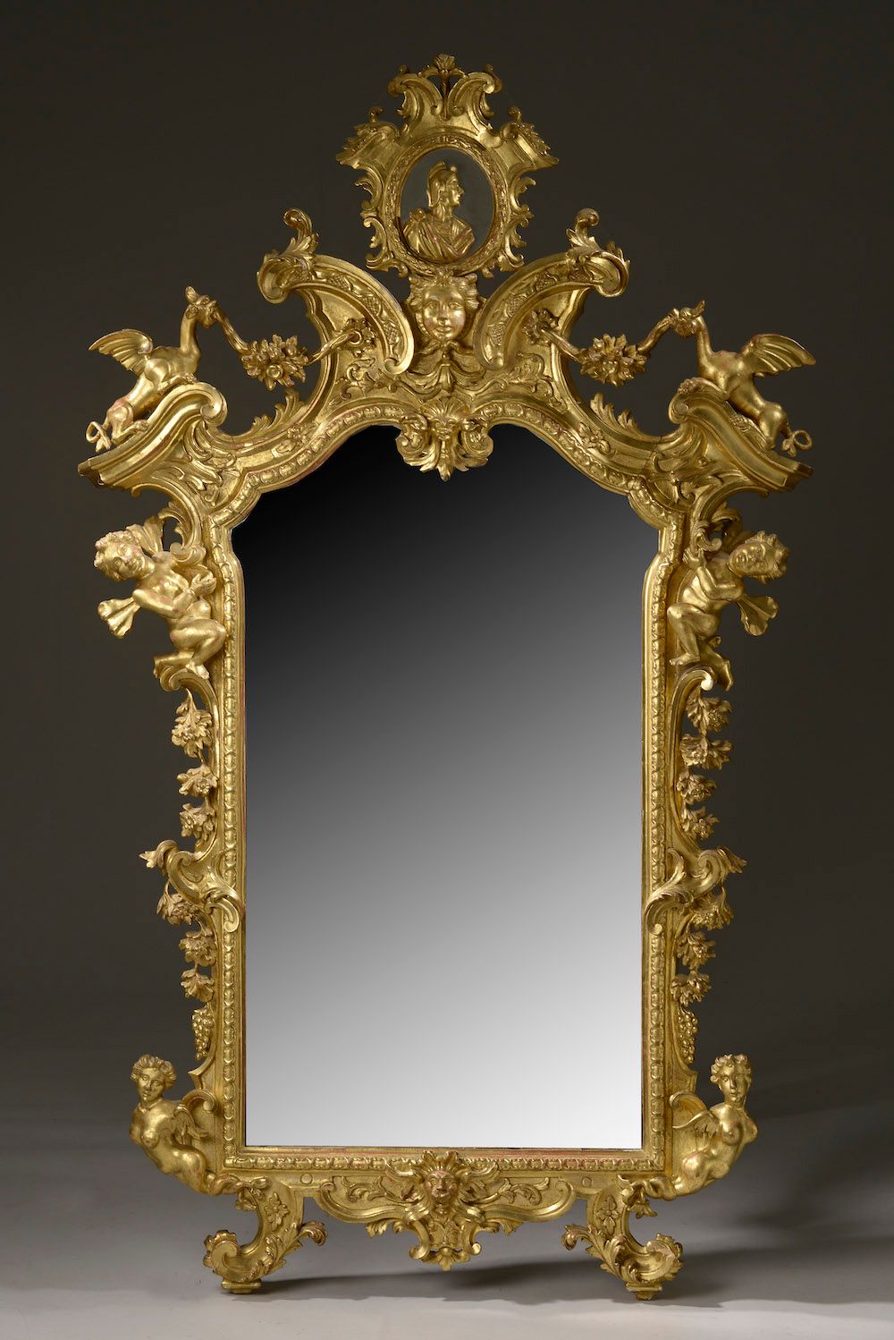 Null Important miroir en bois mouluré, sculpté et doré, le fronton accueillant u&hellip;