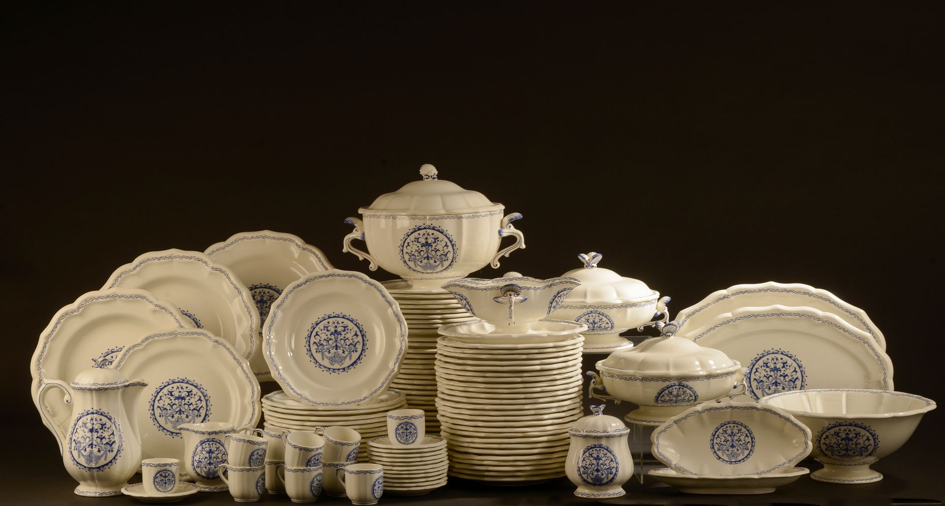 Null 吉恩。

一个陶器服务的一部分，"鲁昂 "模型，有轮廓的边缘和蓝色珐琅装饰的贝伦风格的卷轴的奖章和刺桐边框。它包括 :四十八个餐盘（一个有裂痕），二十&hellip;