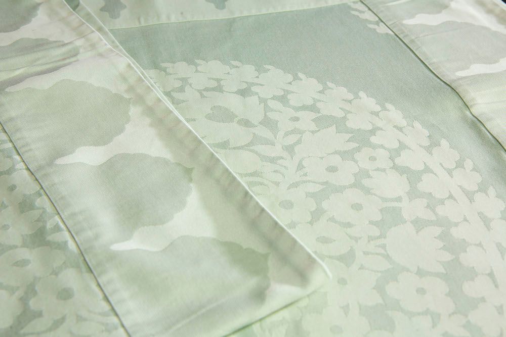 Null CHRISTOFLE.

用柔软的绿色棉布制作的方形桌布，上面装饰着开花的波特。

侧面：127厘米
