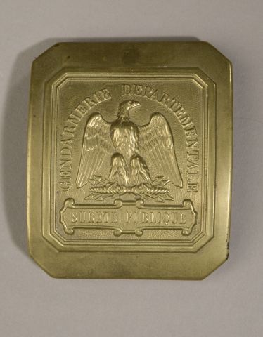 Null 国家宪兵队的黄铜马具牌。背面有固定标签（氧化，使用痕迹）。

拿破仑三世时期。

高度：9厘米。9厘米 - 长度：7.5厘米