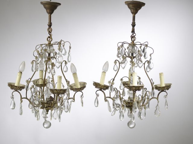 Null 在BAGUÈS之家的品味中。

一对小型镀金金属吊灯，四盏灯，装饰有吊坠和玻璃珠（小变形）。

20世纪中期。

高度：56厘米。高度：56厘米