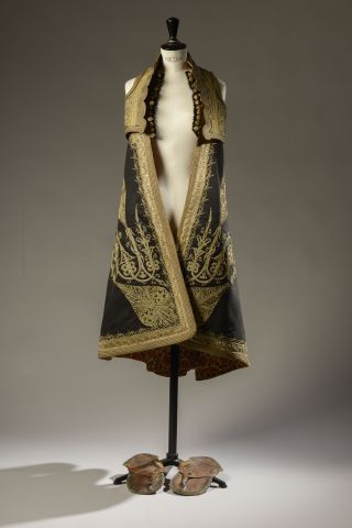 Null 
绣有金线和辫子的黑色帆布的传统服装，包括长袍和马甲（已穿）。




可能是土耳其，19世纪。









附有一双皮凉鞋（已磨损）。
