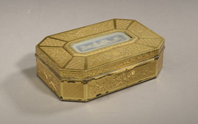 Null 一个长方形的镀金金属盒，上面刻有植物图案，盒盖上装饰着一个描绘云中战车的韦格伍德瓷盘（有磨损的痕迹，缺少镀金，氧化）。

19世纪下半叶。

高度：4&hellip;