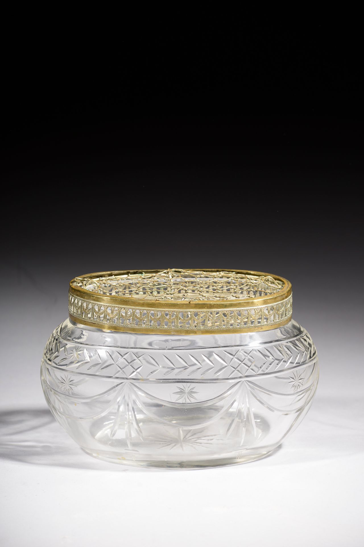 Null 一个椭圆形的切花水晶花瓶，镀金的金属框架上有垂下的柱子装饰（镀金的地方有磨损）。

19世纪晚期。

长度：23厘米