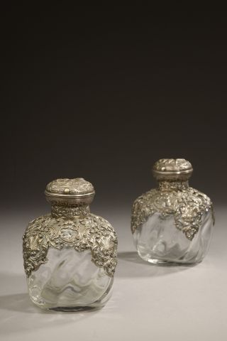 Null 一对方形玻璃瓶，有扭曲的门环和银质的安装，装饰有罗盖尔图案，盖子上有一个动画场景（氧化，有使用的痕迹）。

蟹的标记。

路易十五风格，19世纪末。
&hellip;
