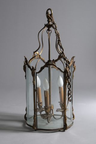 Null 一个铜制的三灯大厅灯笼，有叶状的卷轴装饰，玻璃是弯曲的（一个坏了）。

路易十五风格。

高度：69.5厘米69.5厘米 - 直径：32厘米