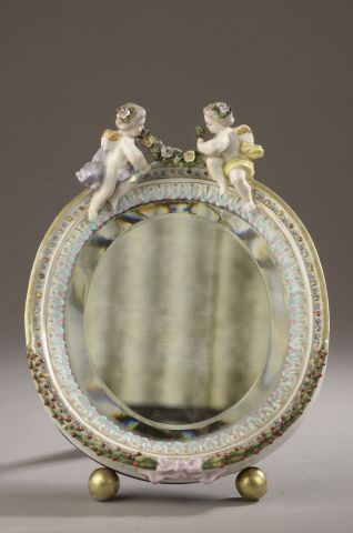 Null 小镜子，框架为多色瓷器，有镀金的圆角，装饰有小天使和花环（镀金有小的缺失）。

20世纪初。

高度：28厘米28 cm - 宽度 : 21 cm