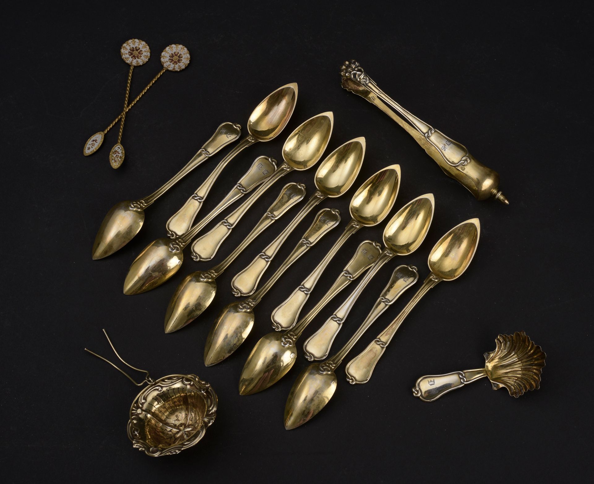 Null 一套镀金茶具，上面有DB的字样，装饰有结网，包括12个小勺子，一个糖钳和一个茶勺。

一个茶壶架也是用vermeil制作的。

标识：Minerve &hellip;