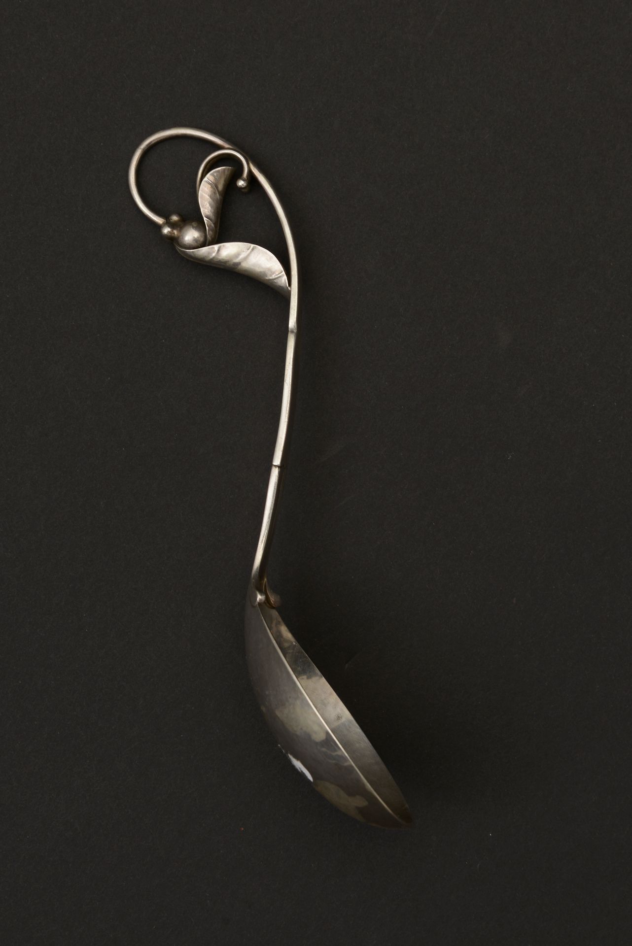 Null 酱汁或奶油勺，卵圆形的勺子是用锤子银做的，手柄是一个树枝的形状，最后是两片叶子交织在一起的球。

丹麦作品，约1940/50年。

进口标志 - 重量&hellip;