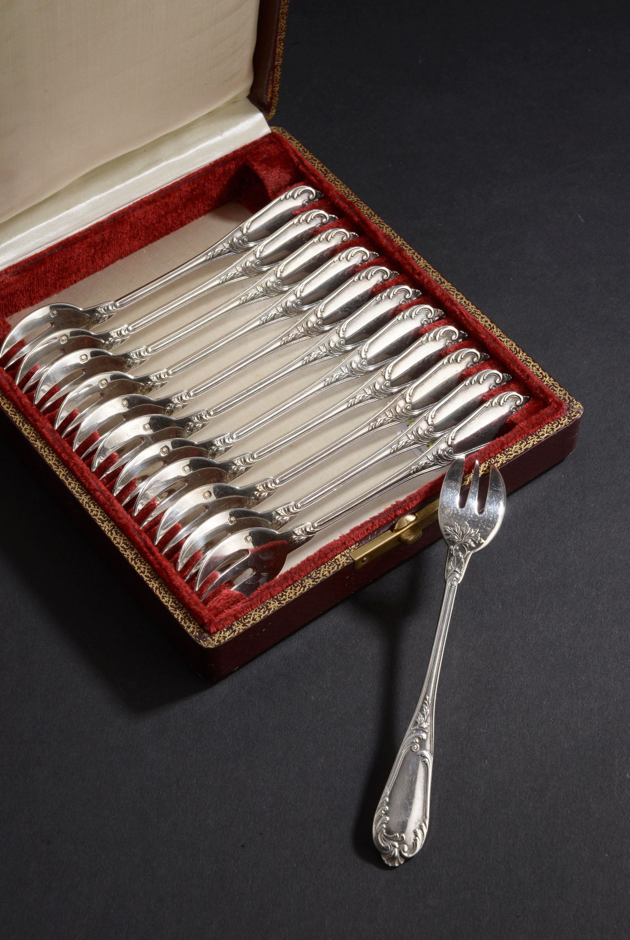 Null Set of twelve silver oyster forks with leafy handles and plain spatula.

Ma&hellip;