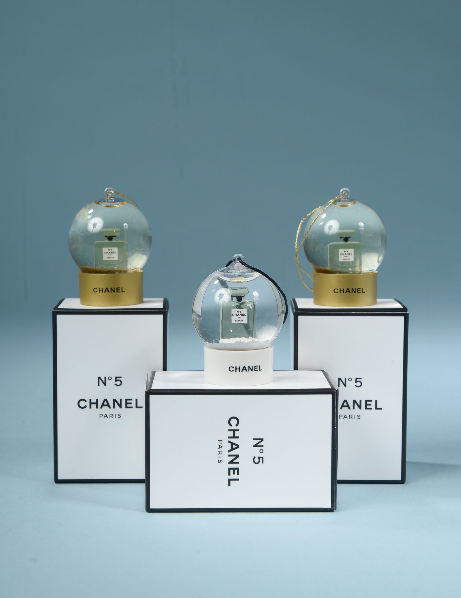 CHANEL. Three mini snow globes to hang, representing th…