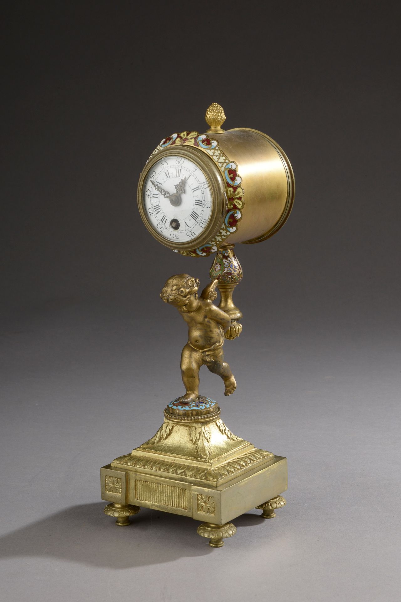 Null 一座带有夹层多色珐琅框架的时钟。钟表由一个小天使携带。 

约1880年。

高度：16和25.5厘米。16和25.5厘米



一个有类似装饰的陶瓷&hellip;