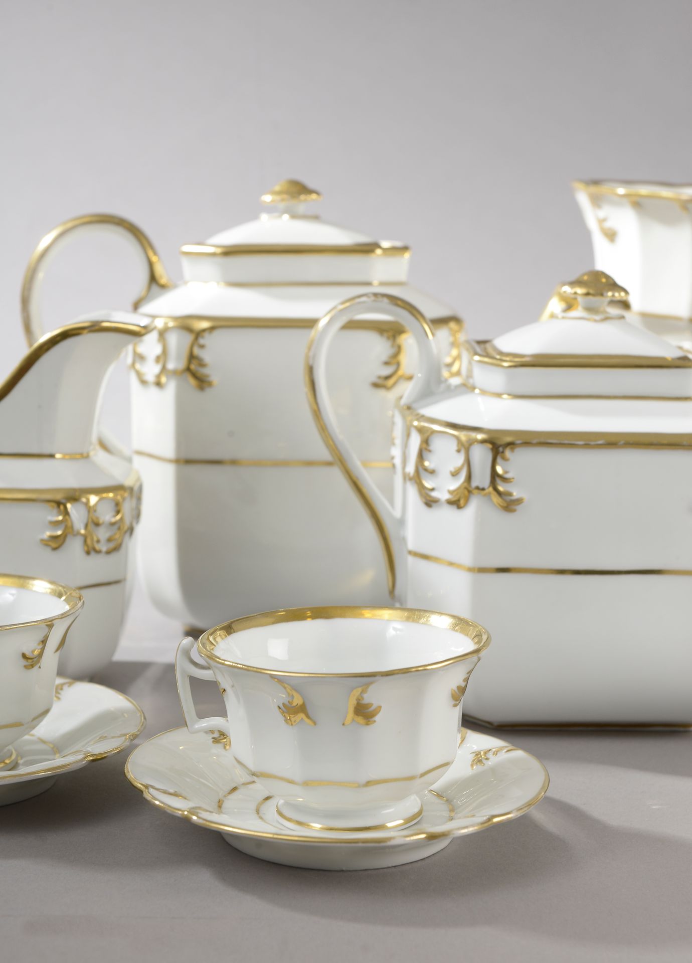 Null 一套巴黎瓷器茶具和咖啡具，上面有镀金的鱼片、卷轴和刺桐叶的装饰（镀金的损失），包括:

- 11个杯（高：6厘米）和12个碟（直径：14厘米）。

-&hellip;