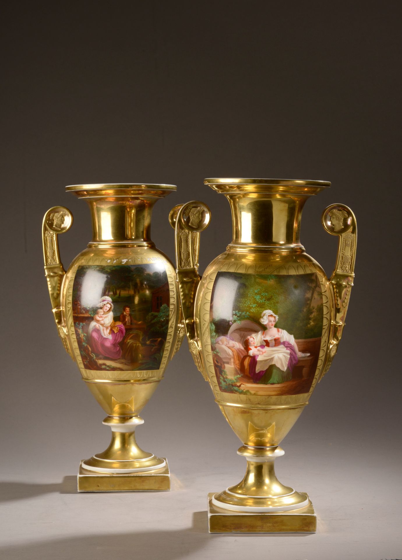 Null 巴黎。
一对瓷质的基座花瓶，有多色的母性场景的装饰，把手有仿古风格的轮廓装饰，背景是哑光和亮金色（磨损）。 
帝国时期。
高度：41厘米
