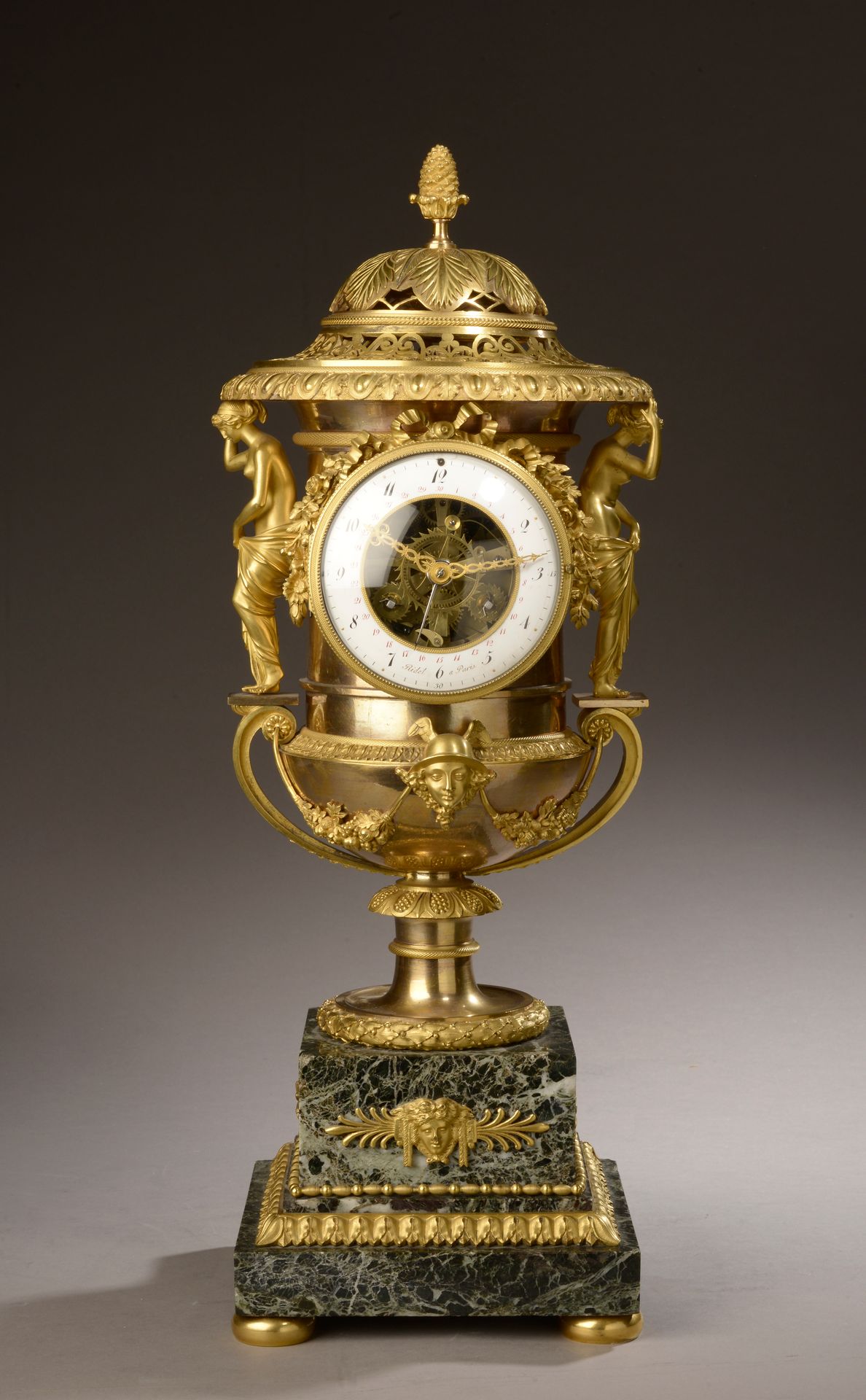 Null 一个有盖的美第奇花瓶钟，带有镂空日历机芯，青铜材质，镀金和抛光，环形的白色珐琅表盘上有黑色的阿拉伯数字小时和分钟，红色的日期，有签名（磨损，珐琅的事故&hellip;