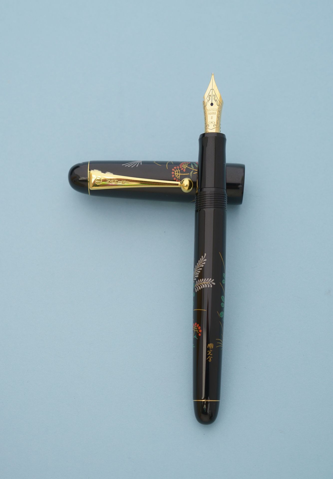 Null NAMIKI "Tradition"。 
钢笔，金属笔身覆盖黑色乌鲁士漆，上面有代表叶子和花朵的Maki-e装饰，有签名，属性为镀金金属，14K黄金笔&hellip;
