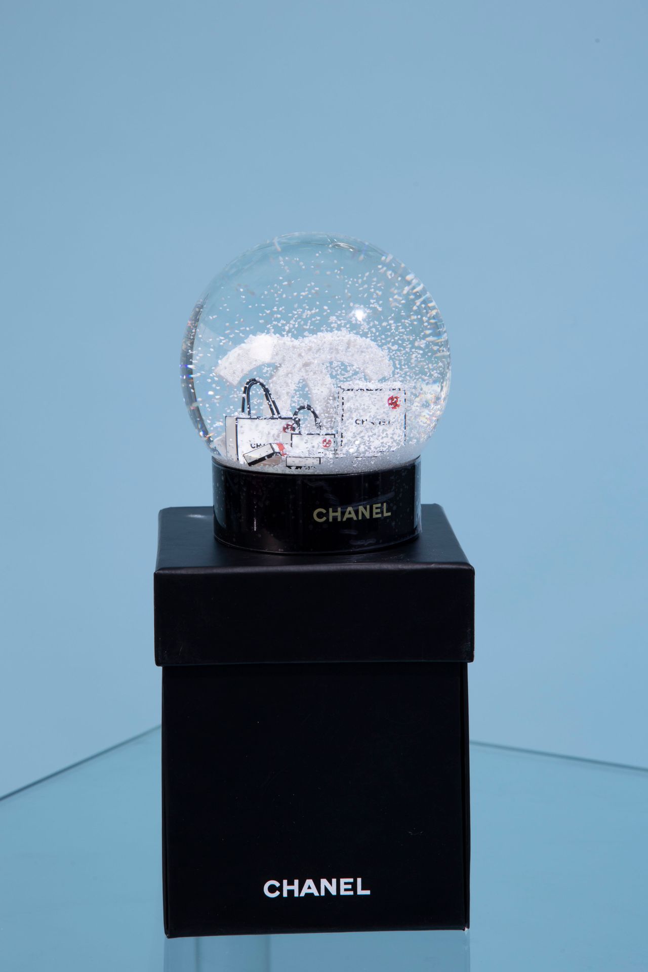Null CHANEL. 
Glass snow globe on black lacquered plastic base featuring the dou&hellip;