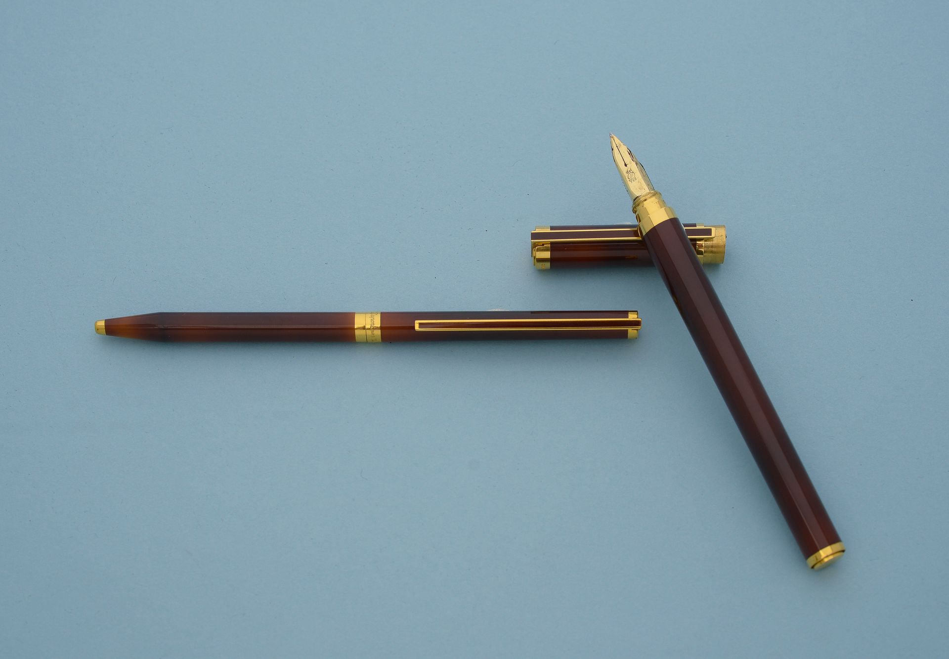 Null ST DUPONT. 
套装包括一支钢笔和一支圆珠笔，笔身为中国焦糖色漆面，属性为镀金，笔尖为18K黄金，尺寸为M中号，填充物为笔芯。 
编号为44J&hellip;
