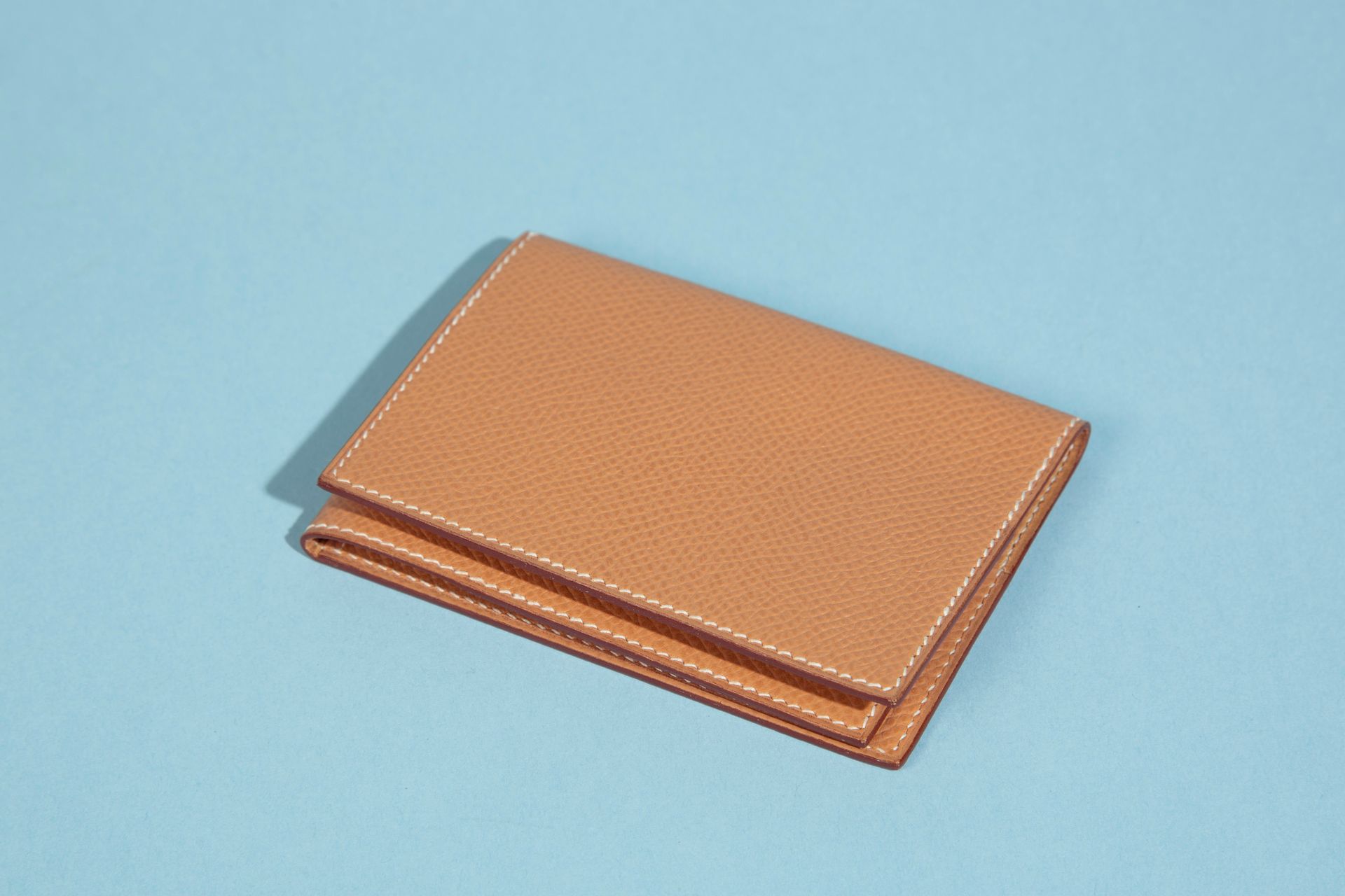 Null HERMÈS. 
Folding card case in beige grained leather.
Height : 7 cm 7 cm - W&hellip;